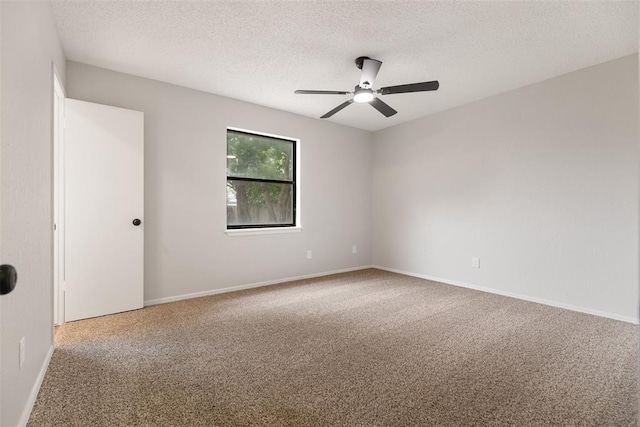 empty room with carpet flooring, a ceiling fan, a textured ceiling, and baseboards
