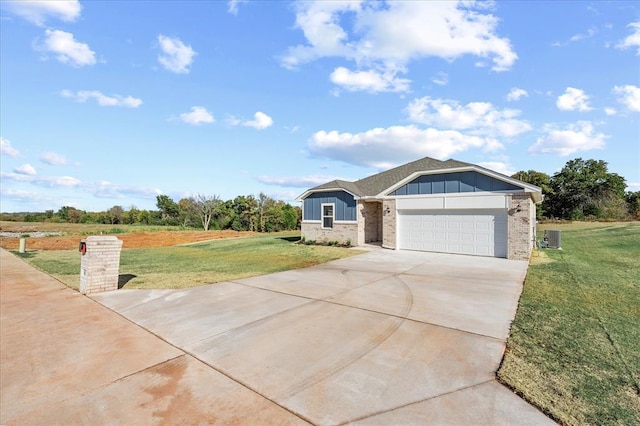 812 Stella Trl, Guthrie, OK 73044 - view of front facade featuring a front lawn, brick siding, board and batten siding, an attached garage, and driveway