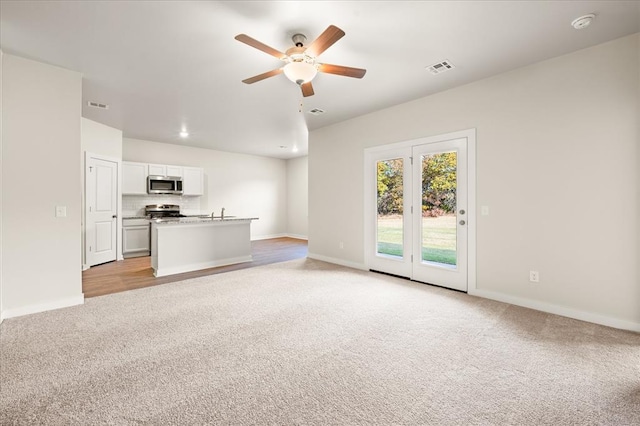 812 Stella Trl, Guthrie, OK 73044 - unfurnished living room featuring ceiling fan, light colored carpet, baseboards, and visible vents