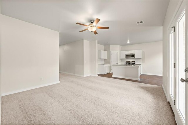 812 Stella Trl, Guthrie, OK 73044 - unfurnished living room with carpet floors, ceiling fan, baseboards, and visible vents
