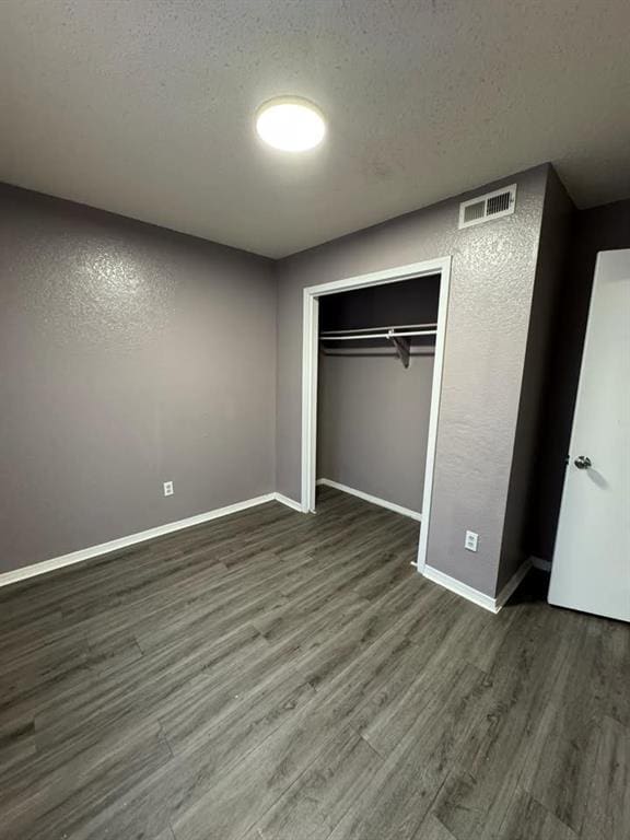 3509 N Nesbitt Ave, Oklahoma City, OK 73112 - unfurnished bedroom featuring wood finished floors, baseboards, a textured ceiling, and a closet