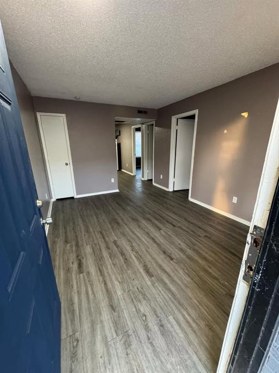 3509 N Nesbitt Ave, Oklahoma City, OK 73112 - spare room with wood finished floors, a textured ceiling, and baseboards