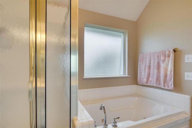 bathroom featuring a whirlpool tub, vaulted ceiling, and a shower stall