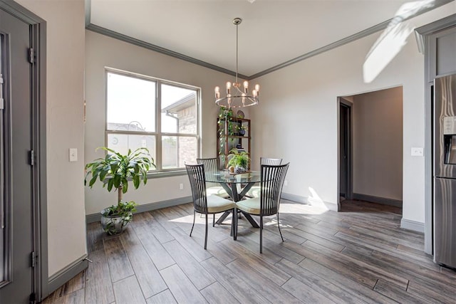 dining area with ornamental molding, a chandelier, wood finished floors, and baseboards