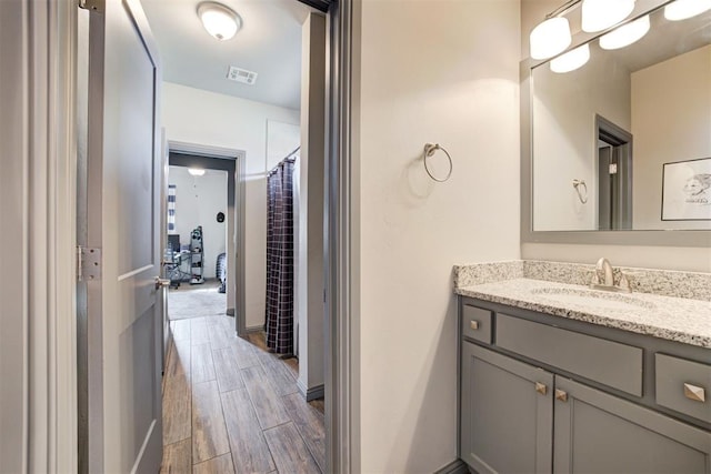 full bathroom featuring vanity, wood finished floors, and baseboards