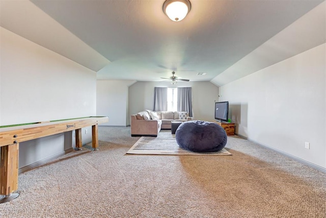 living room featuring lofted ceiling, carpet flooring, a ceiling fan, and baseboards