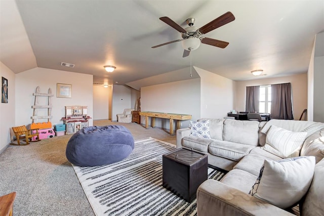carpeted living room featuring a ceiling fan and vaulted ceiling