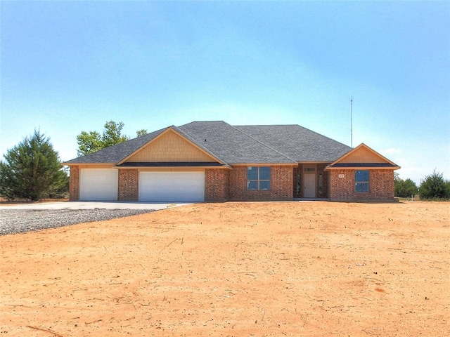 343787 E 870th Rd, Chandler, OK 74834 - single story home with a shingled roof, an attached garage, gravel driveway, and brick siding
