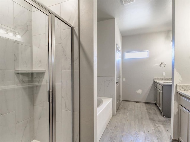 343787 E 870th Rd, Chandler, OK 74834 - bathroom with vanity, a stall shower, a garden tub, and wood finished floors