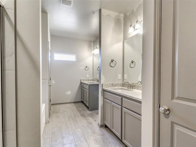 343787 E 870th Rd, Chandler, OK 74834 - full bathroom featuring a sink, two vanities, wood finished floors, and visible vents