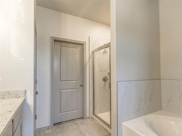 343787 E 870th Rd, Chandler, OK 74834 - full bathroom featuring vanity, a shower stall, a garden tub, and wood finished floors