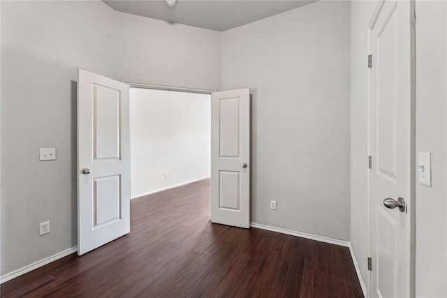 unfurnished bedroom featuring baseboards and dark wood finished floors