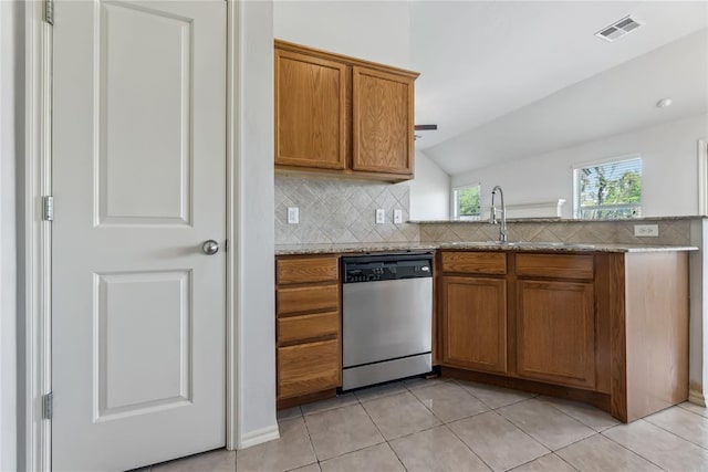 kitchen featuring stainless steel dishwasher, visible vents, brown cabinets, a sink, and backsplash