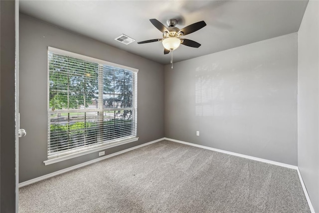 spare room with baseboards, ceiling fan, carpet, and visible vents
