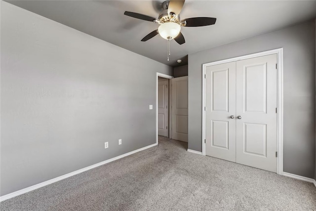 unfurnished bedroom featuring baseboards, a ceiling fan, carpet, and a closet