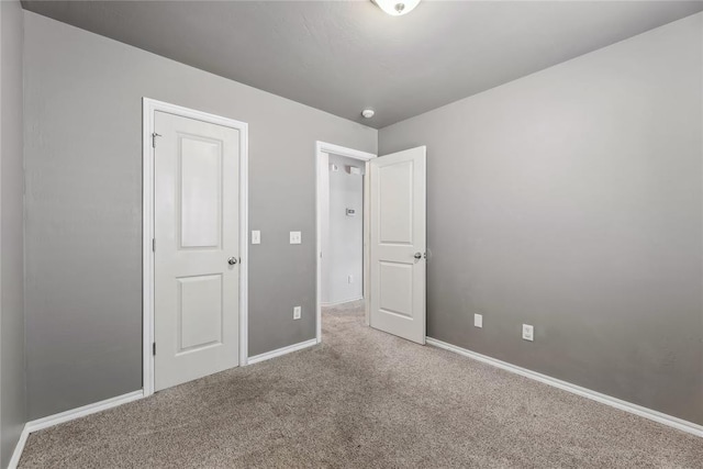 unfurnished bedroom with baseboards and carpet