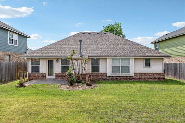 rear view of property with brick siding, a fenced backyard, a lawn, and a patio
