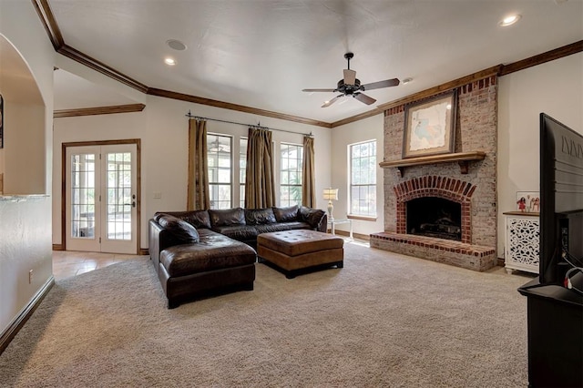 living room with a ceiling fan, a brick fireplace, baseboards, ornamental molding, and carpet