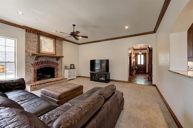 living room with arched walkways, ceiling fan, light carpet, and baseboards