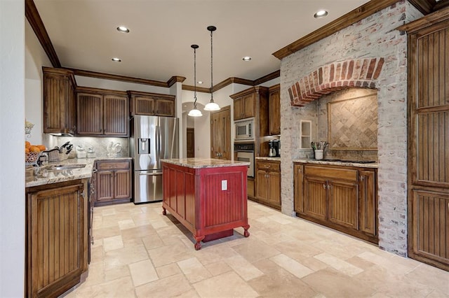 kitchen with appliances with stainless steel finishes, a sink, a center island, tasteful backsplash, and ornamental molding