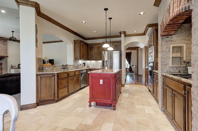 kitchen with arched walkways, tasteful backsplash, a center island, and appliances with stainless steel finishes