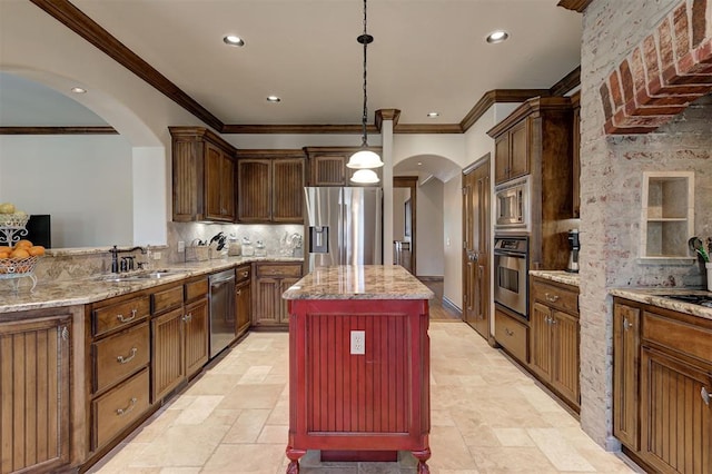 kitchen featuring crown molding, appliances with stainless steel finishes, a sink, arched walkways, and backsplash