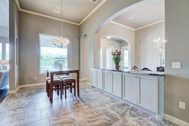 dining room with arched walkways, a notable chandelier, plenty of natural light, and ornamental molding