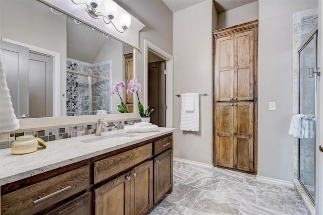 bathroom with vanity, baseboards, backsplash, and a shower stall