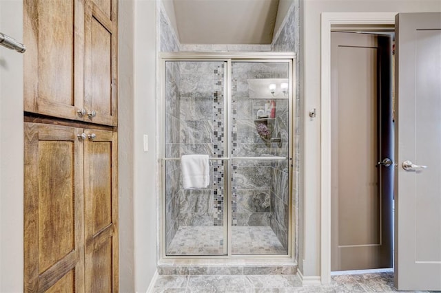 bathroom with baseboards and a stall shower