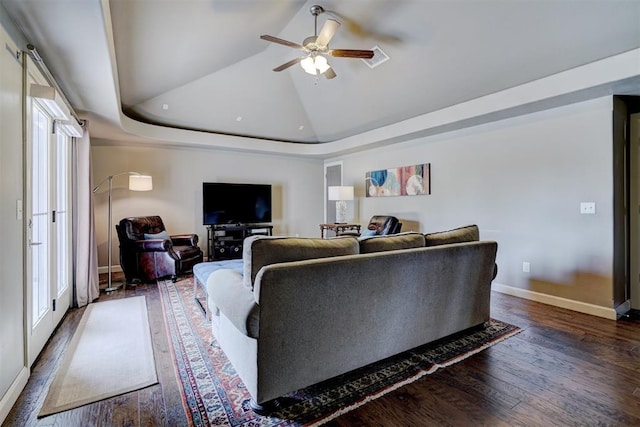 living area featuring baseboards, ceiling fan, dark wood-style floors, and a wealth of natural light