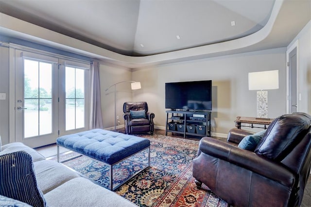 living room featuring baseboards and a raised ceiling