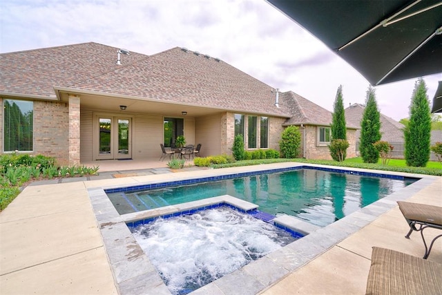 outdoor pool featuring french doors, a patio, and an in ground hot tub