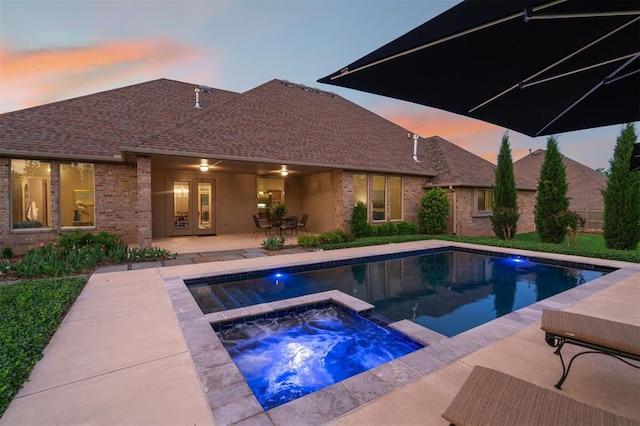 pool with an in ground hot tub and a patio area