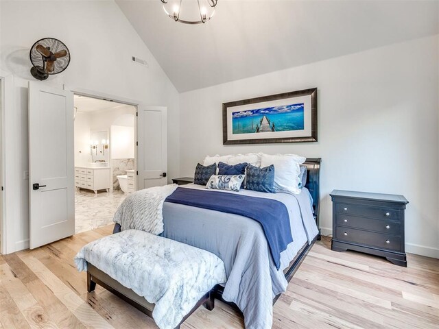 bedroom featuring connected bathroom, high vaulted ceiling, a chandelier, baseboards, and light wood-type flooring