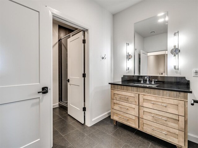 bathroom with vanity, visible vents, baseboards, tile patterned floors, and a stall shower