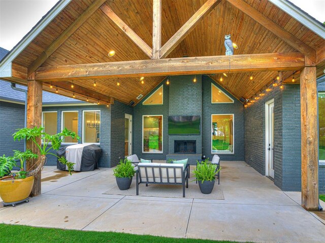 view of patio with an outdoor living space with a fireplace and area for grilling