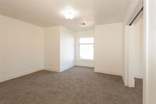 unfurnished bedroom featuring baseboards, carpet, and visible vents