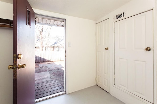 doorway to outside featuring visible vents and concrete floors