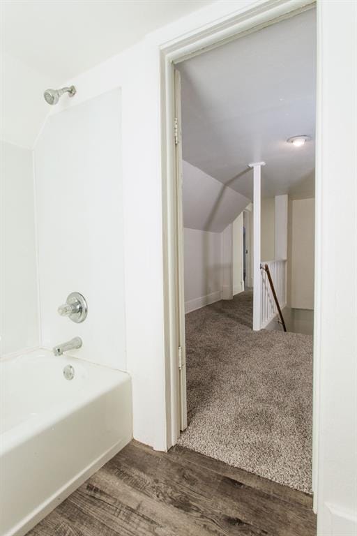 bathroom with shower / bathtub combination, wood finished floors, and lofted ceiling