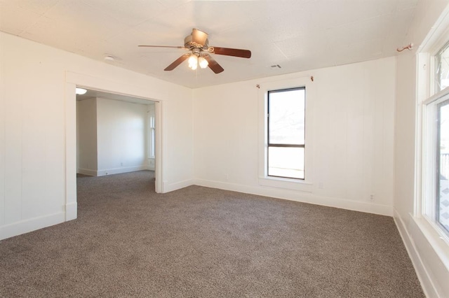 spare room featuring ceiling fan, carpet, and a wealth of natural light