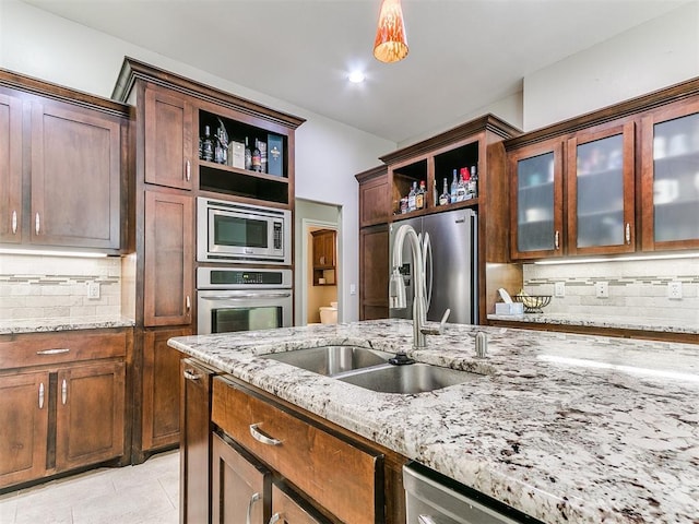 kitchen featuring open shelves, a sink, tasteful backsplash, and stainless steel appliances