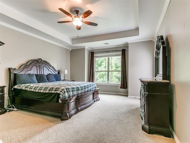 bedroom featuring visible vents, baseboards, ornamental molding, light carpet, and a tray ceiling
