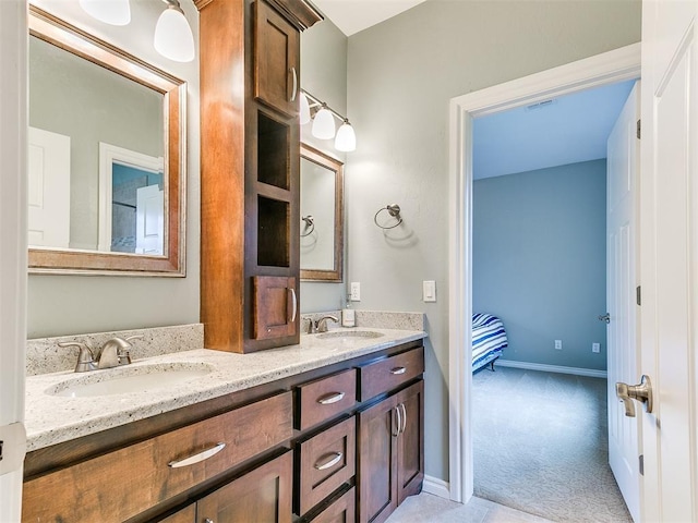 full bath with a sink, baseboards, and double vanity