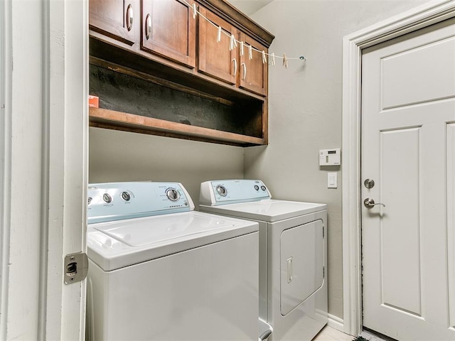 washroom featuring independent washer and dryer, baseboards, and cabinet space