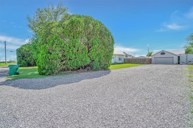 view of front of house with fence, driveway, a front lawn, and a garage
