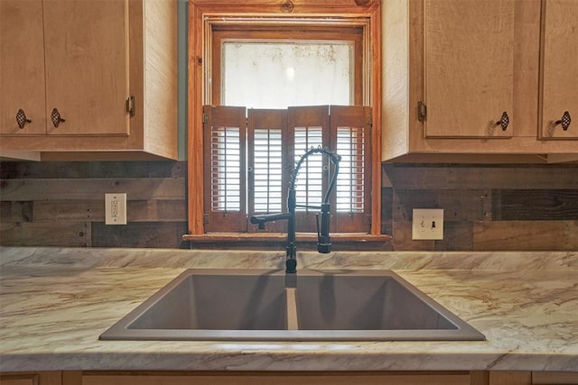 kitchen with light countertops, backsplash, and a sink
