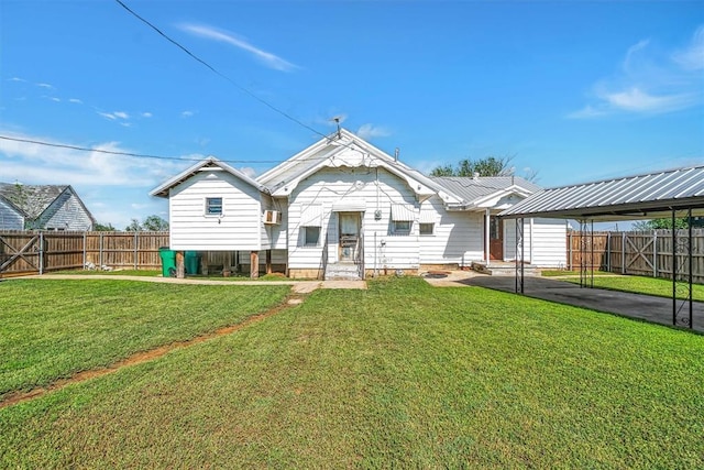 rear view of property featuring a lawn, fence, and an attached carport