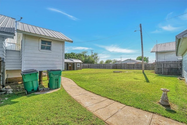 view of yard featuring a storage shed, an outbuilding, and a fenced backyard