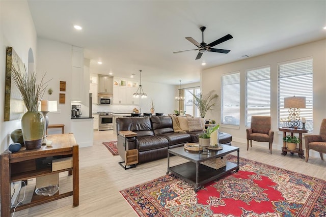 living room with recessed lighting, ceiling fan with notable chandelier, light wood-type flooring, and visible vents