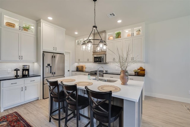 kitchen featuring backsplash, stainless steel appliances, visible vents, and a sink